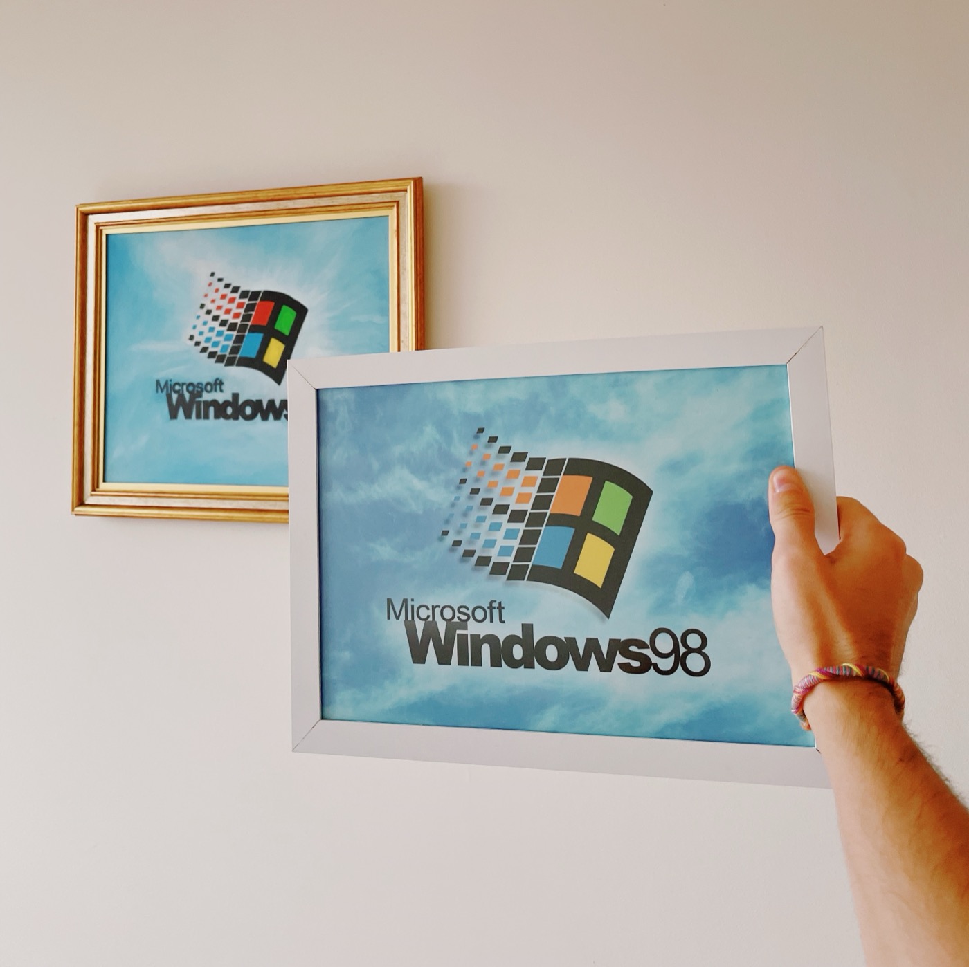 Framed Windows 98 artwork held up on a wall